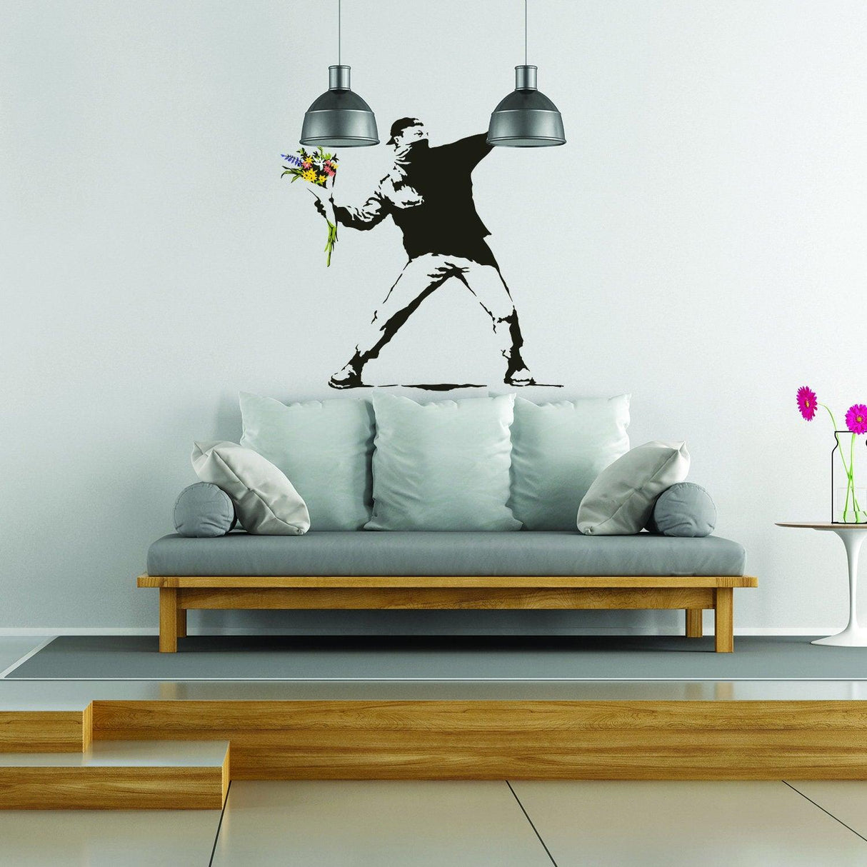 Banksy Flower Throw Wall Vinyl Sticker featuring a man throwing flowers as wall art over a modern couch.