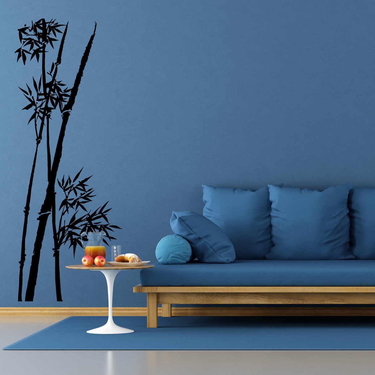 Bamboo wall vinyl sticker in black design on blue wall above modern blue sofa, enhancing home decor.