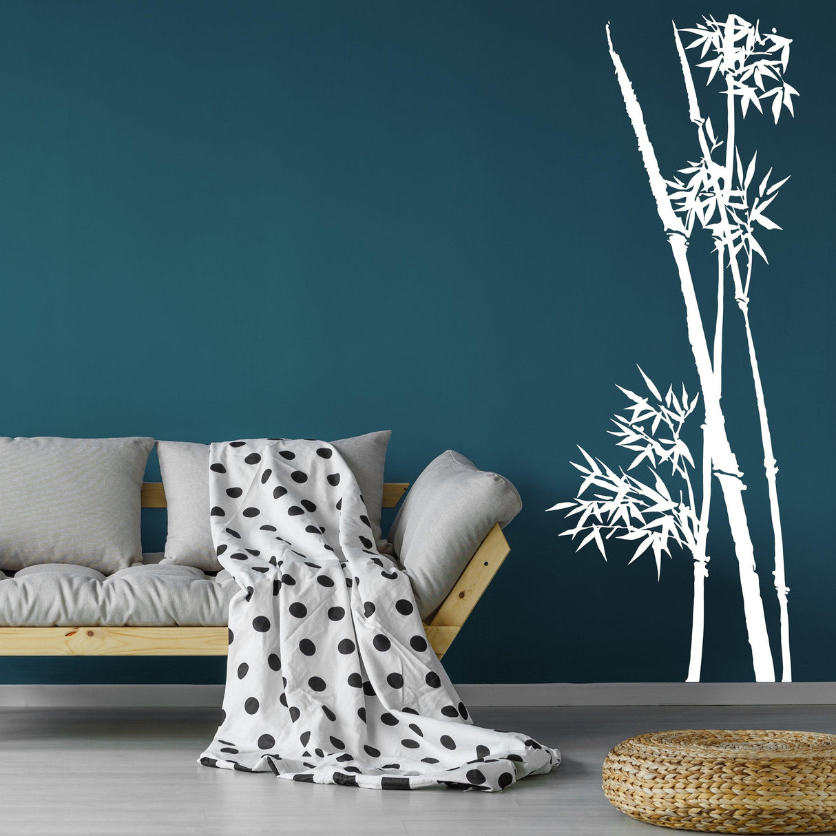 Bamboo wall vinyl sticker on teal wall, creating a tranquil decor with white bamboo stalks beside a couch and blanket.