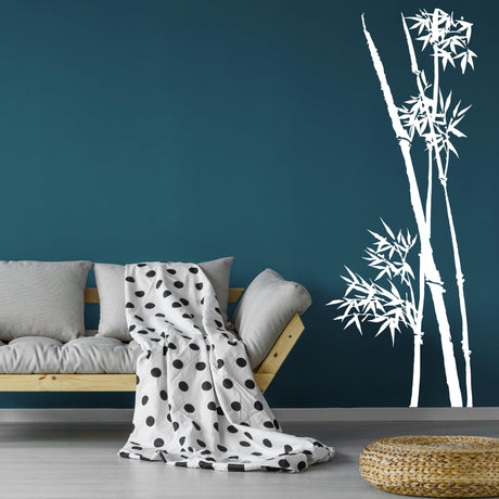 Bamboo wall vinyl sticker on teal wall, creating a tranquil decor with white bamboo stalks beside a couch and blanket.