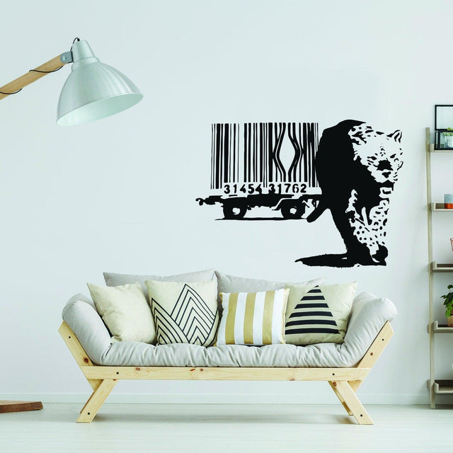 Banksy Leopard Barcode Wall Sticker on a living room wall above a modern couch with decorative pillows.