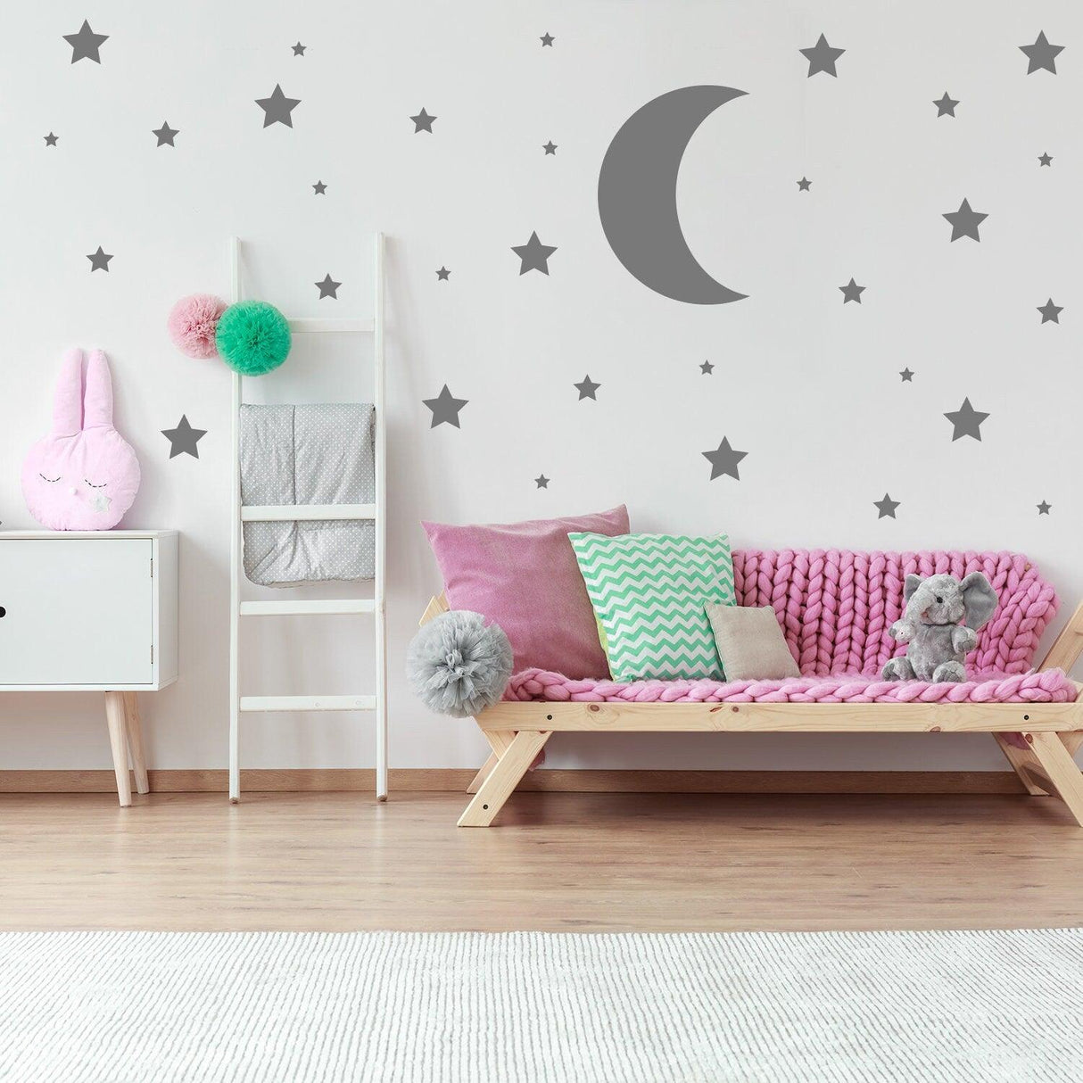 Nursery featuring 115x star wall stickers and crescent moon decal, cozy pink seating, and playful decor.