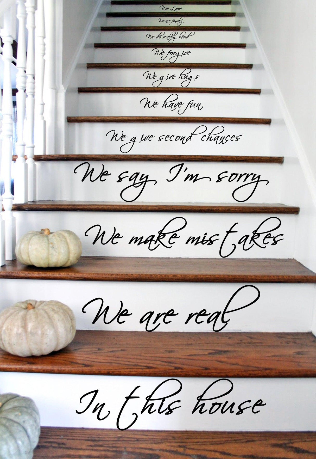 Staircase with 'In this house' vinyl quote decals showcasing family values and love.