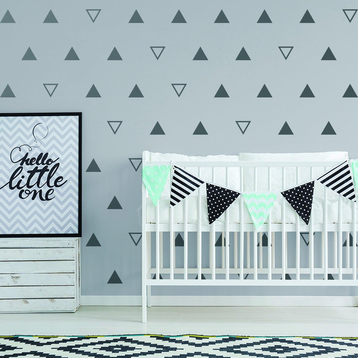 Nursery kids room featuring black triangle vinyl wall decals, crib, and playful decorations.