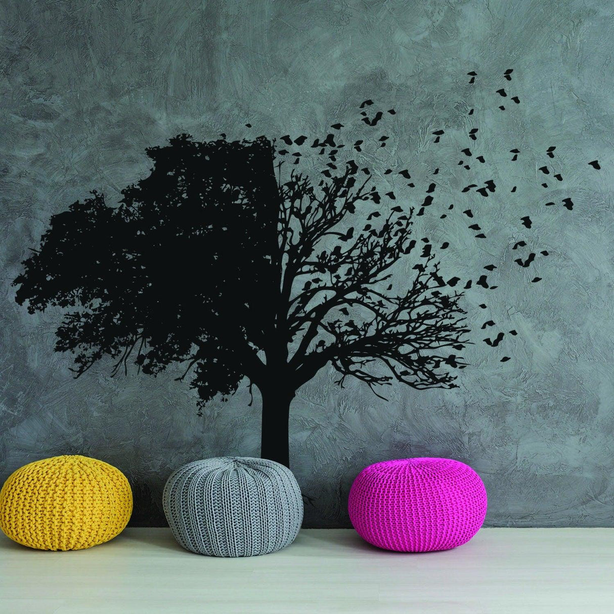 Tree wall decal in black design with birds, accompanied by colorful poufs in a modern living space.