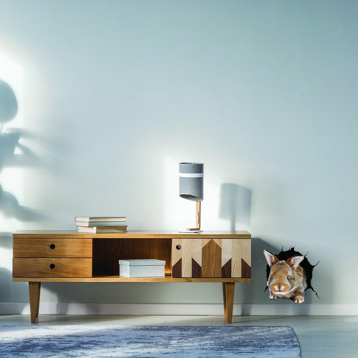 3D rabbit wall decal bursting through wall near wooden console table.