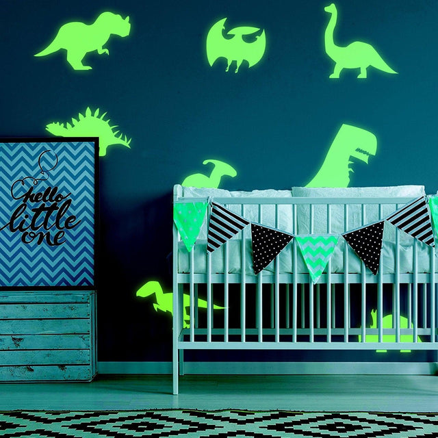 Glow in dark dinosaur wall decals in a boy's room, featuring various dinosaur designs around a crib.