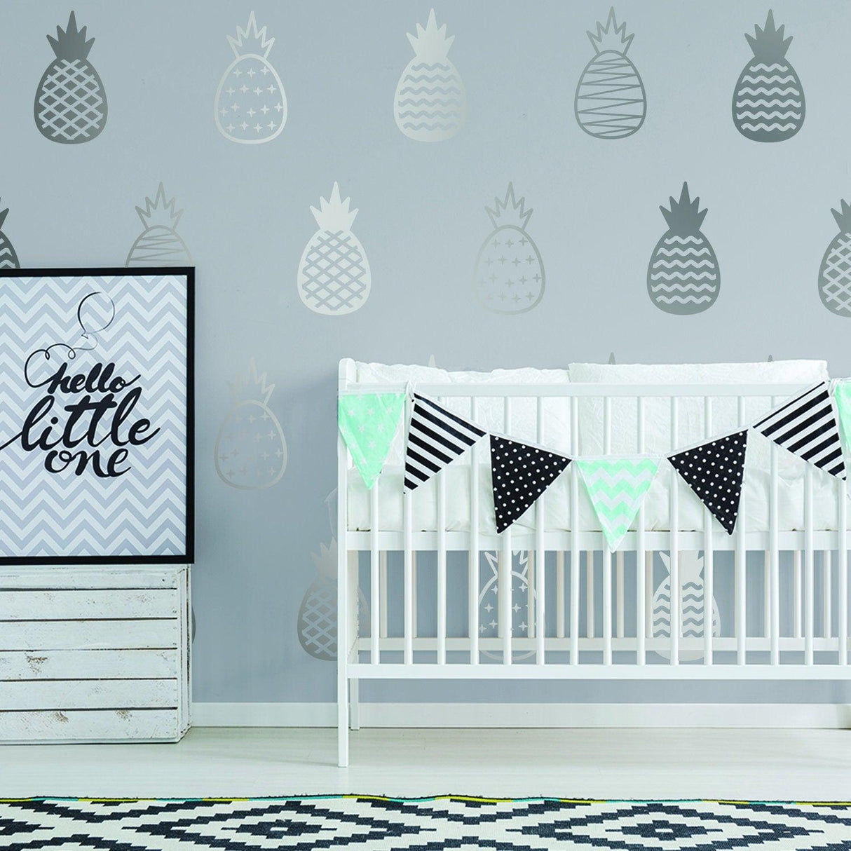 Pineapple wall decals in a nursery with a crib and a decorative banner, creating a cheerful decor.