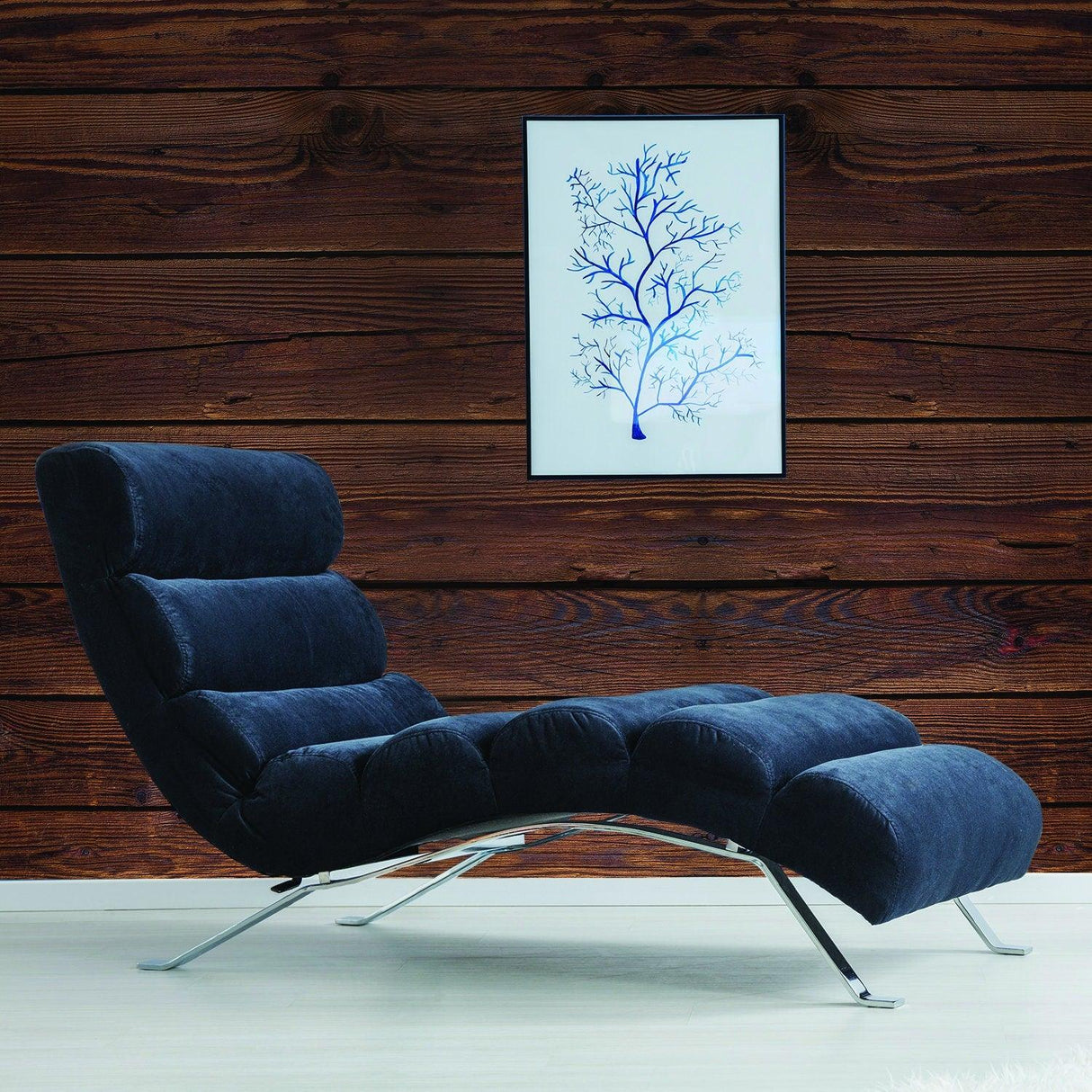 Stylish lounge chair beside a wooden wall, featuring an art piece with a blue tree design.