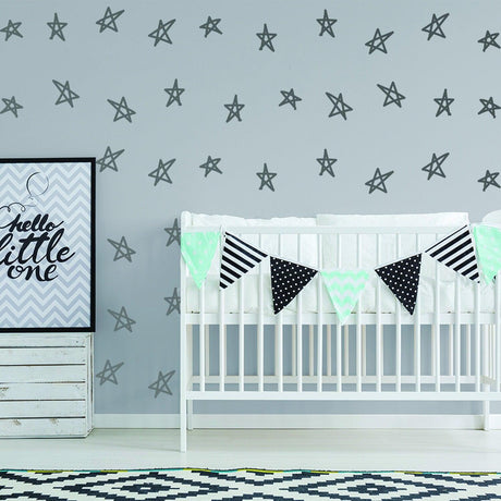 Baby nursery decorated with star stickers and a banner for a stylish baby shower theme.
