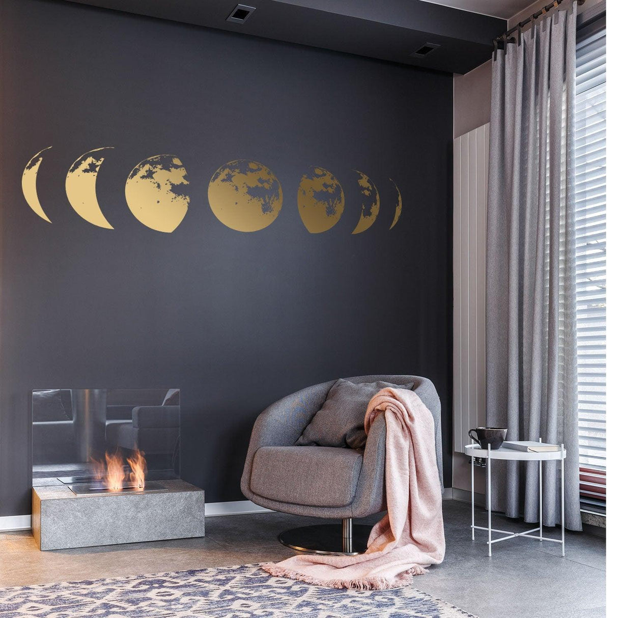 Gold moon phases wall decal displayed in a modern living room with gray walls and stylish furniture.
