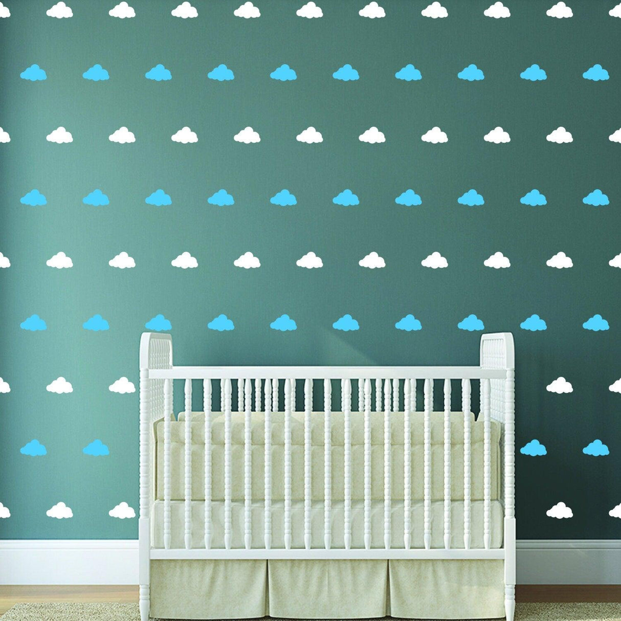 40 cloud wall decals in blue and white on a dark green nursery wall above a white crib.