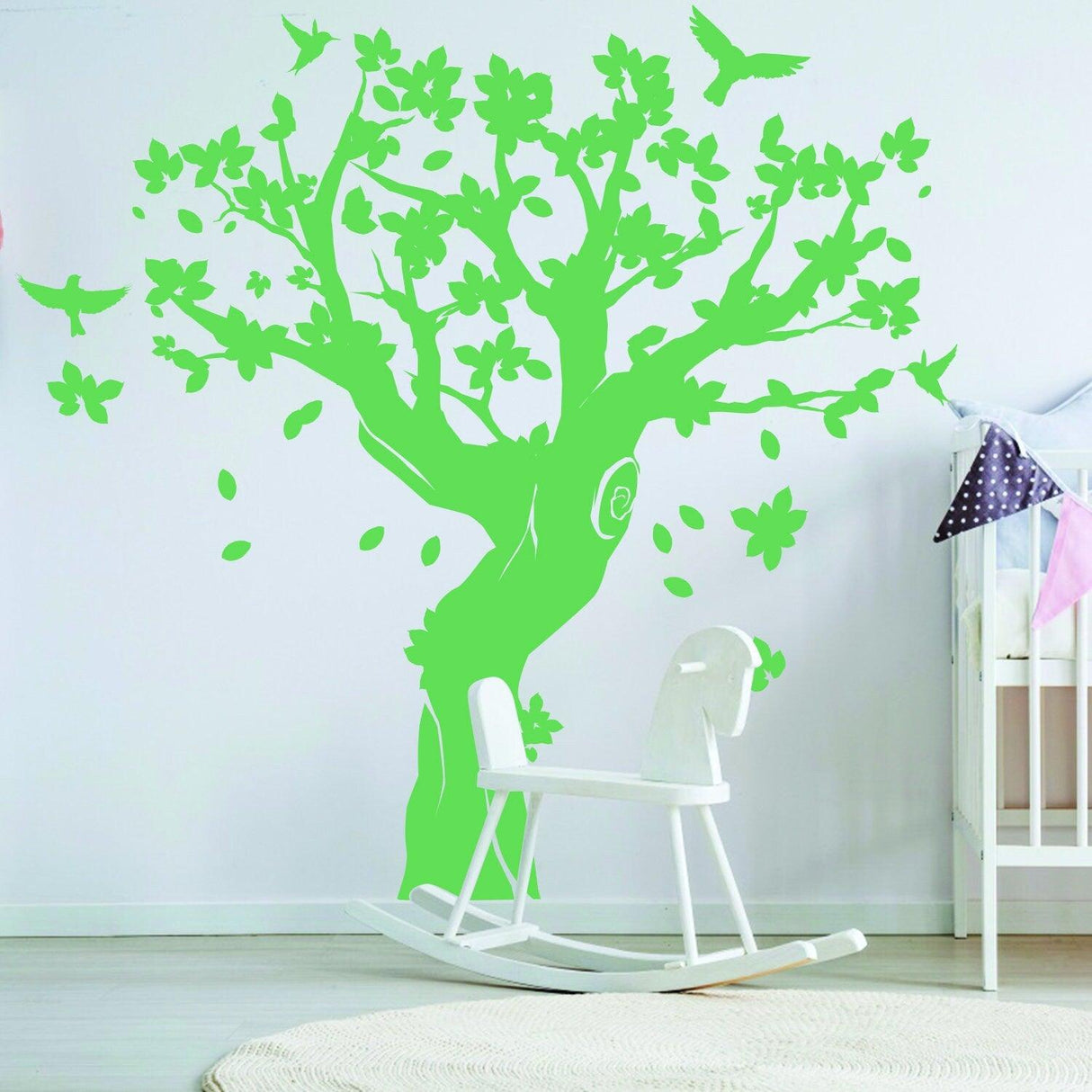 Large green tree wall decal with birds and flowers in a nursery room, adding charm and whimsy to kids' decor.