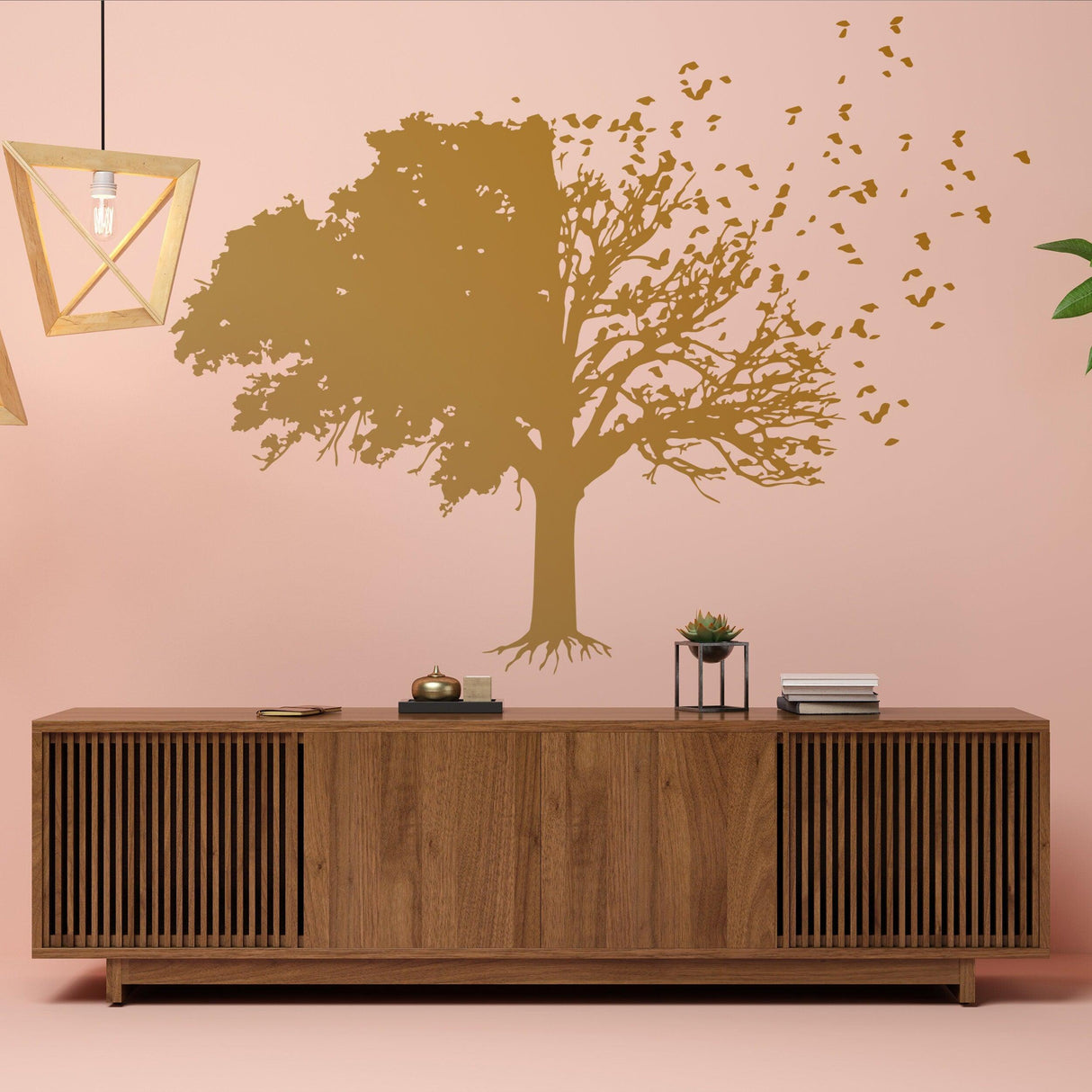 Tree wall decal in gold color on pink wall above wooden cabinet, showcasing nature-inspired home decor.