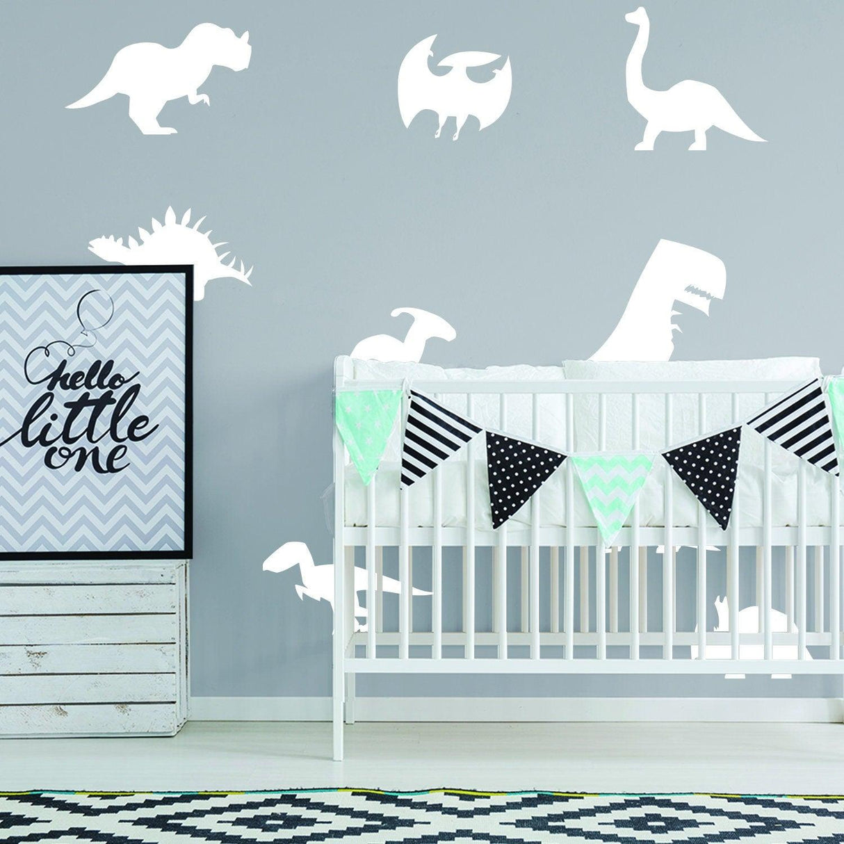 Glow in dark dinosaur wall decals in a nursery, featuring various dino designs and a cute banner.