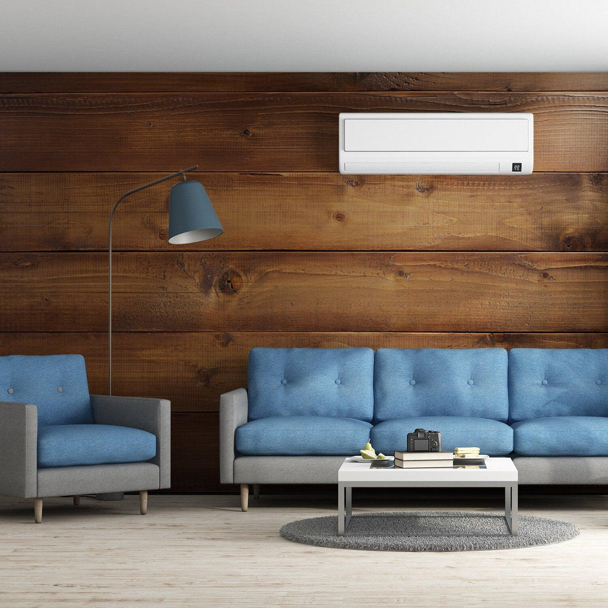 Stylish living room featuring blue sofas against a wooden wall with air conditioning and modern decor.