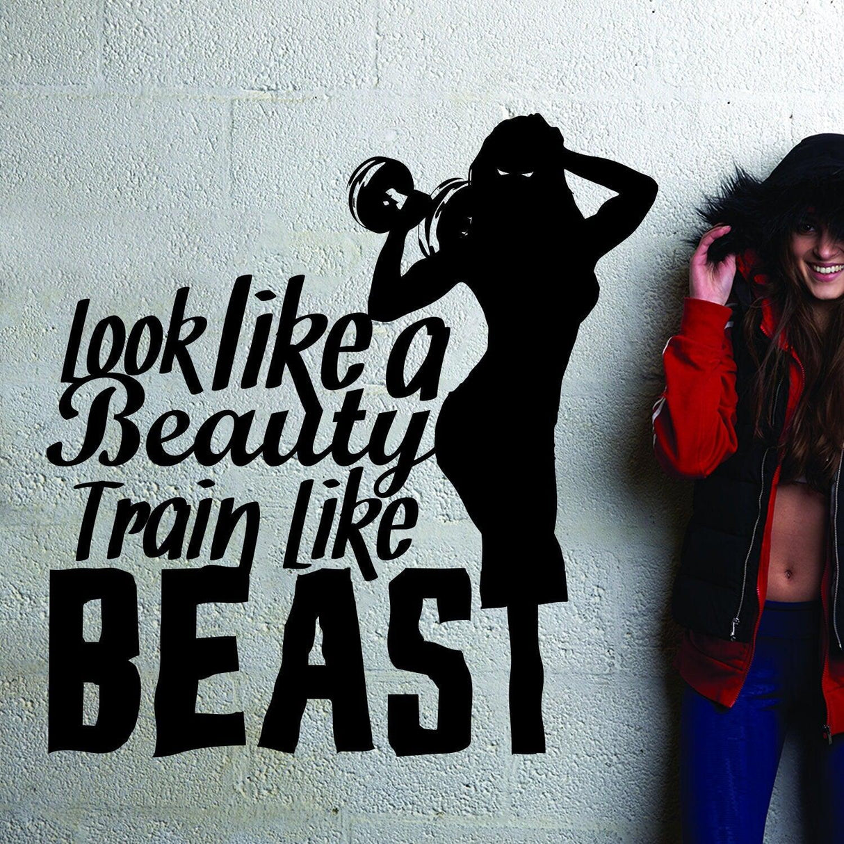 Vinyl decal quote 'Look like a Beauty, Train like a Beast' in fitness gym setting with woman lifting dumbbell.