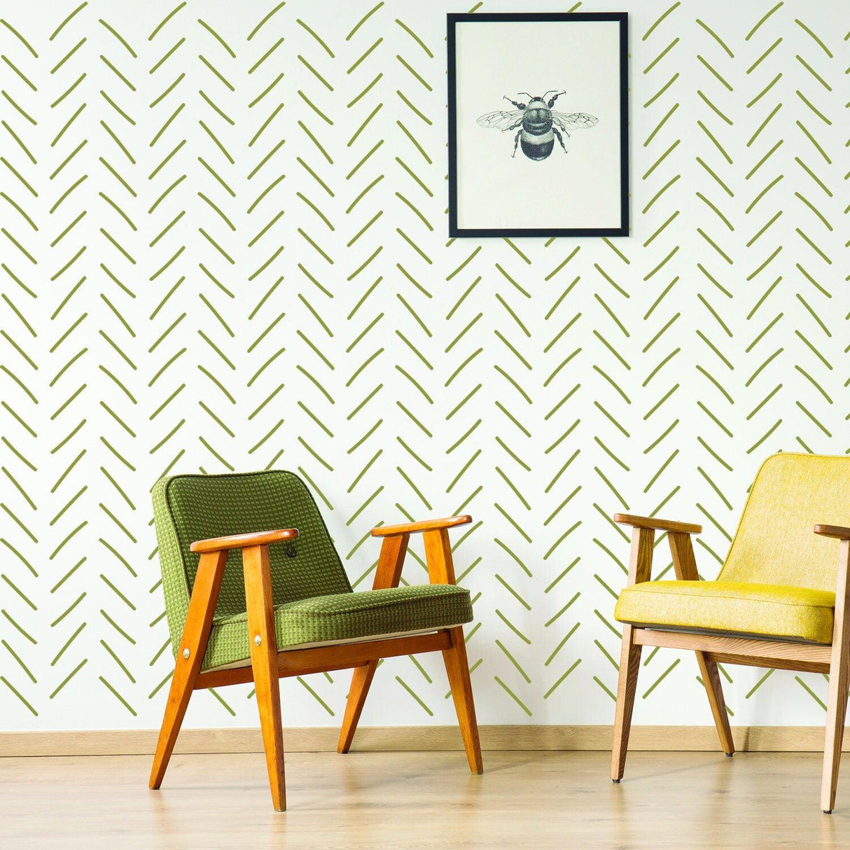 Stylish herringbone wallpaper with green stripes in modern living room, featuring wooden chairs and framed bee art.