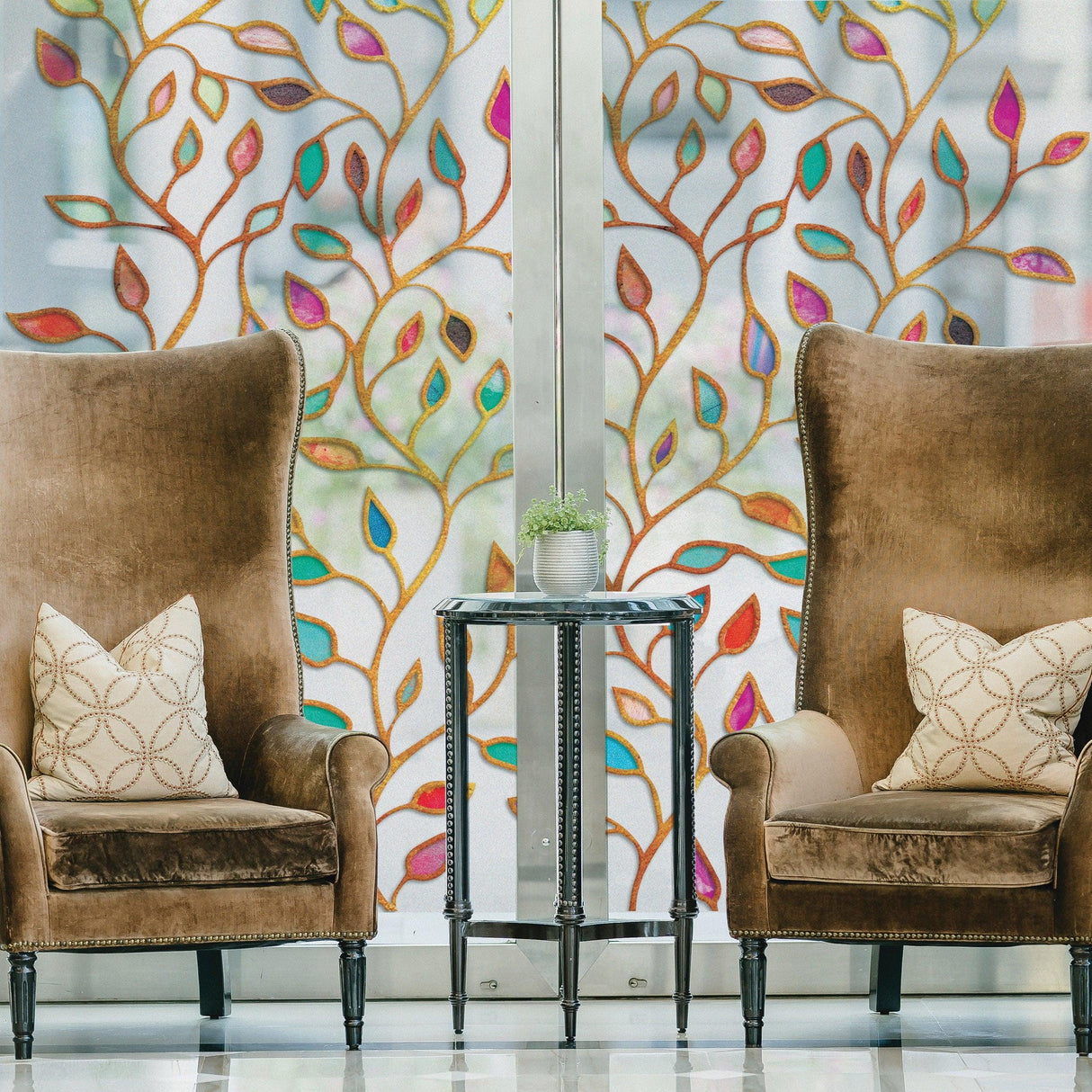 Elegant leaf-patterned frosted window film behind cozy chairs, enhancing privacy and decor in a stylish living space.
