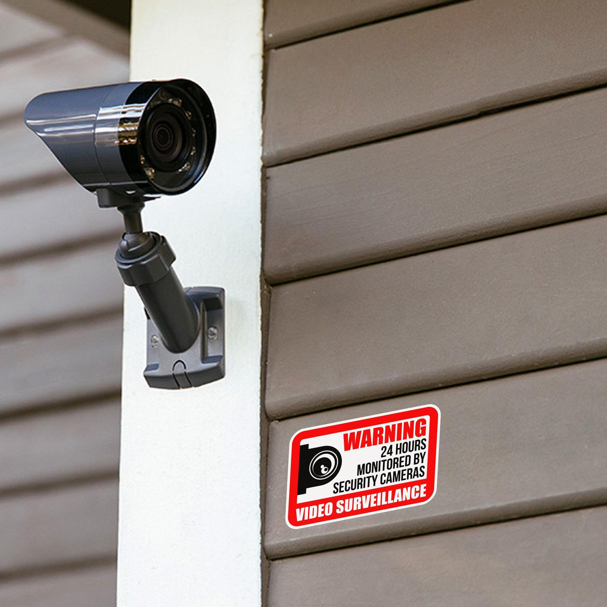 Video camera surveillance sign displayed next to a security camera on an outdoor wall, promoting safety and awareness.
