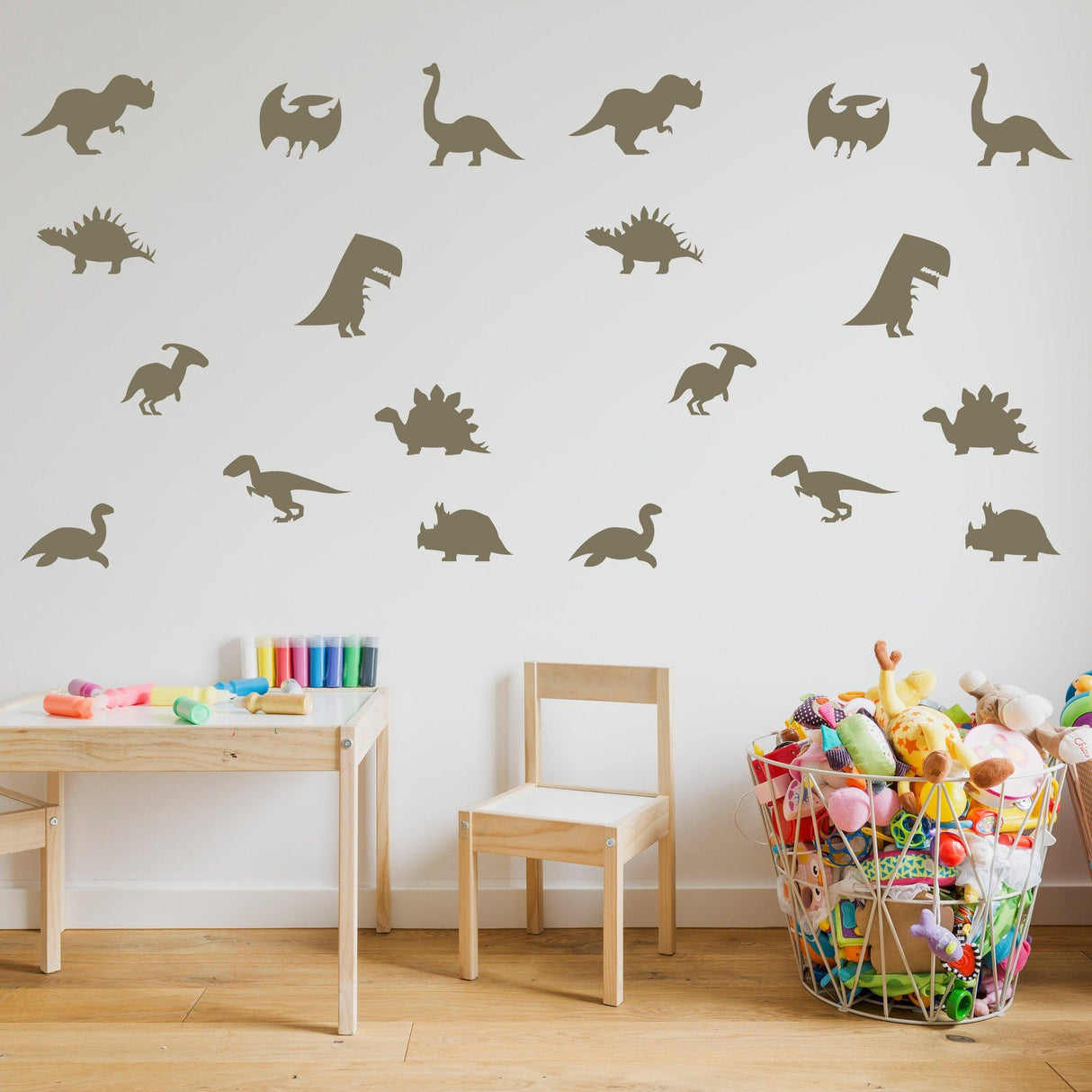 40 dinosaur silhouette wall decals in a baby room, featuring various sizes and colors on a neutral wall.