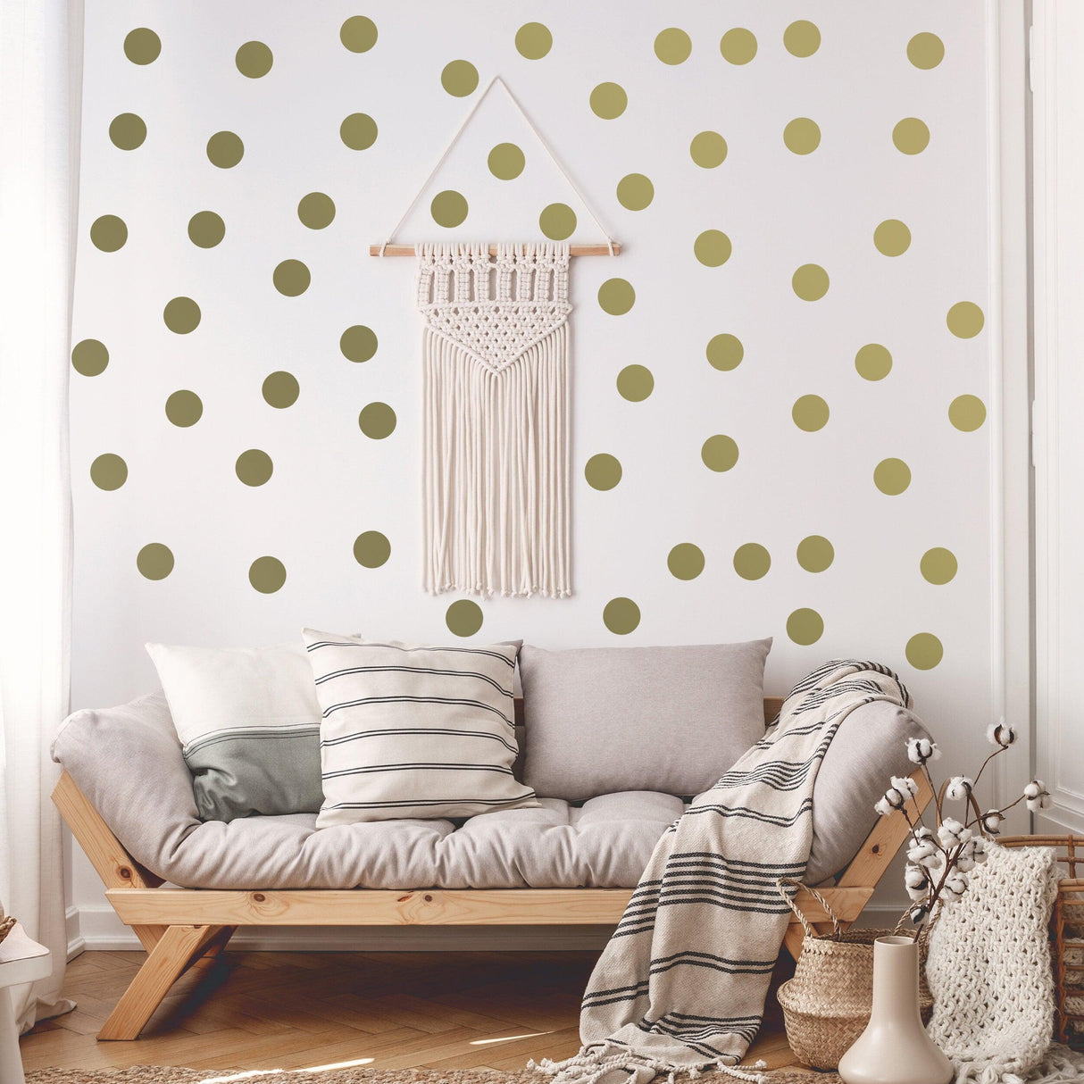 Stylish living room featuring gold circle wall stickers on white walls, cozy sofa, and macrame wall decor.