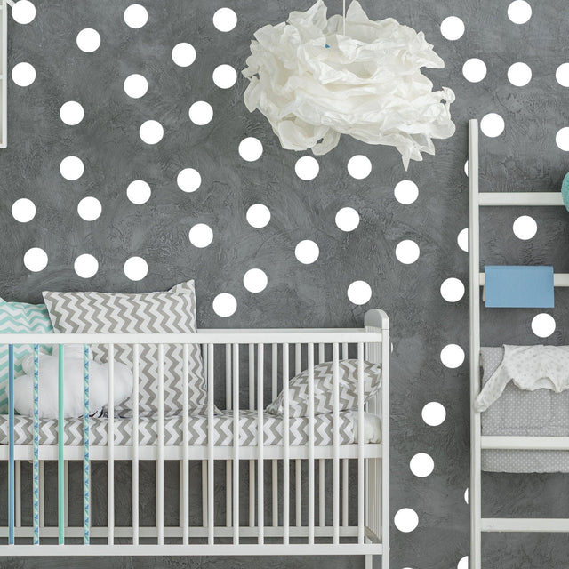 Stylish baby nursery featuring white circle wall stickers on grey wall, creating a modern and playful decor.