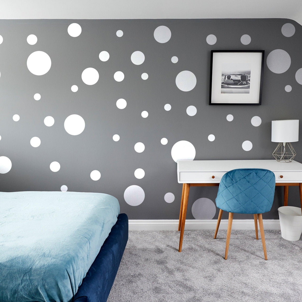 Decorative gray wall featuring white round circle dot stickers in a stylish bedroom.