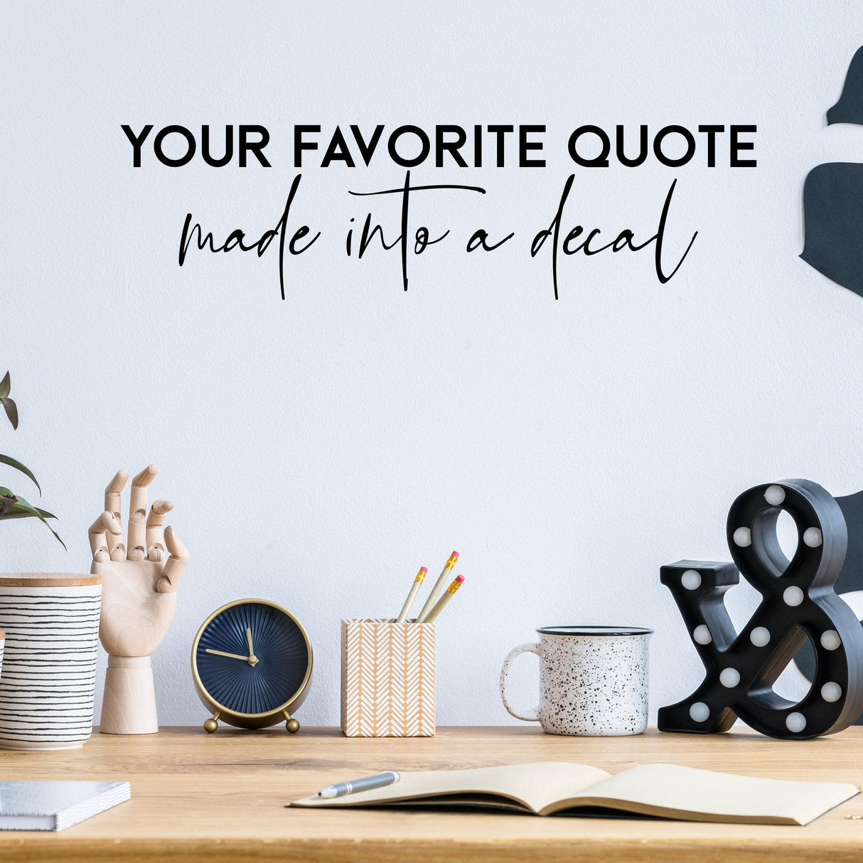 Custom vinyl quote decal on wall above a stylish desk with decorative items, personalized home decor.