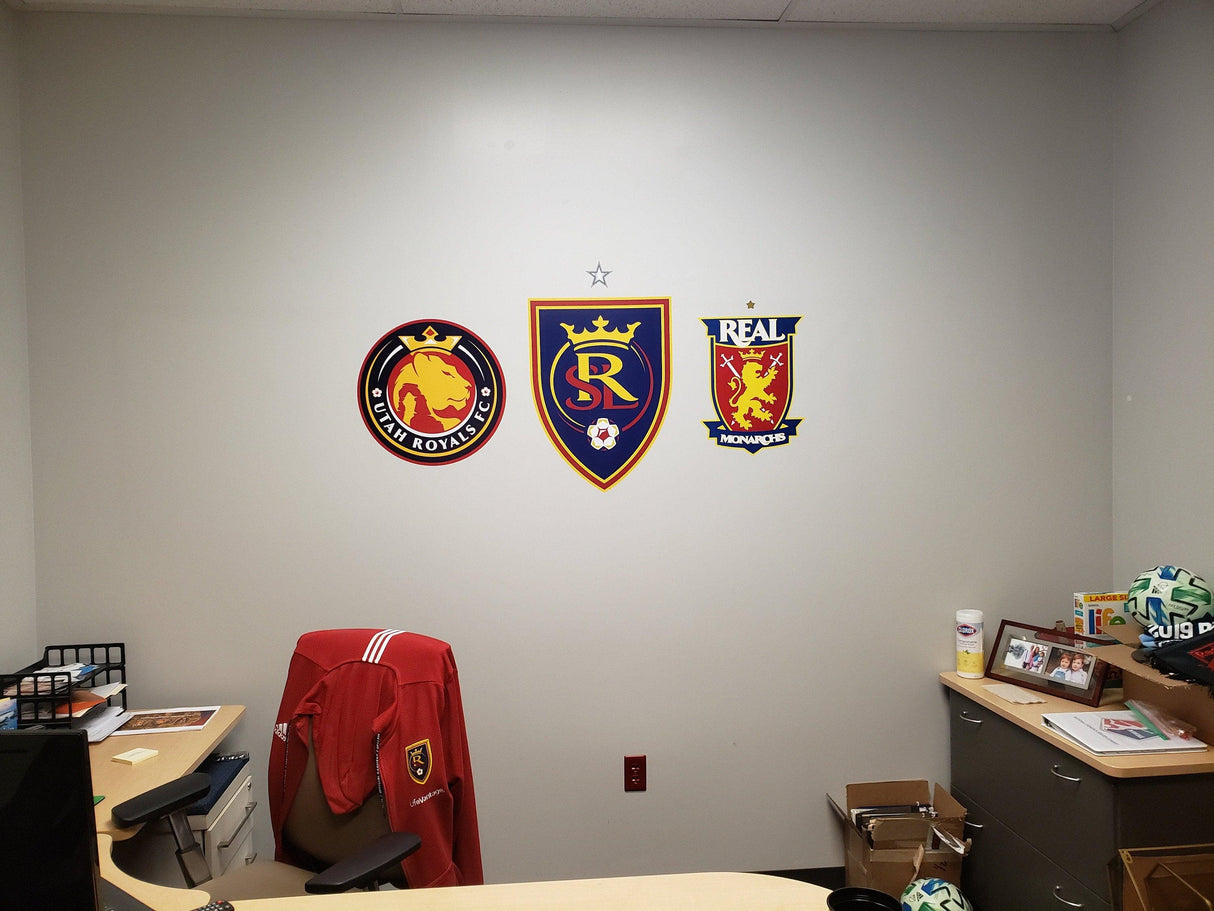 Wall display featuring Real Salt Lake soccer team logos and a red jersey in an office setting.