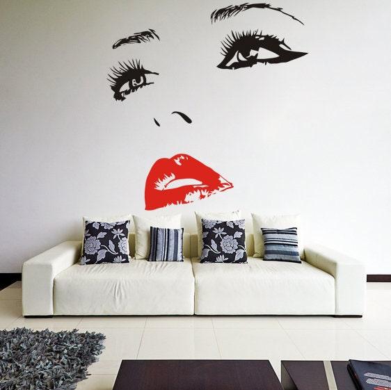 Stylish wall decal of a woman's face with bold red lips above a modern white sofa in a chic living room.