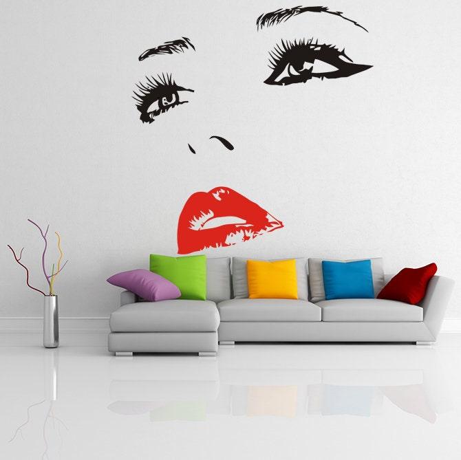 Elegant female eye and red lips wall decal above a modern sofa in a stylish living room.