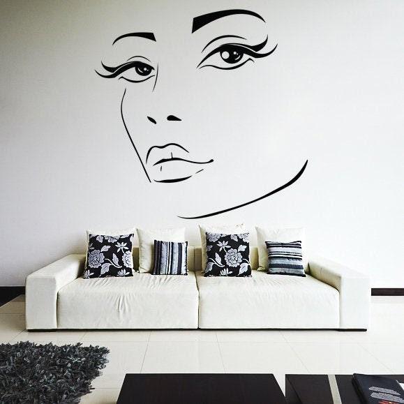 Elegant woman eye wall decal featuring long lashes and styled eyebrows in a stylish bedroom setting.