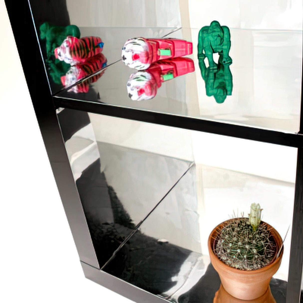 Silver chrome interior vinyl sticker wrap reflecting colorful toys and a cactus in a modern display cabinet.