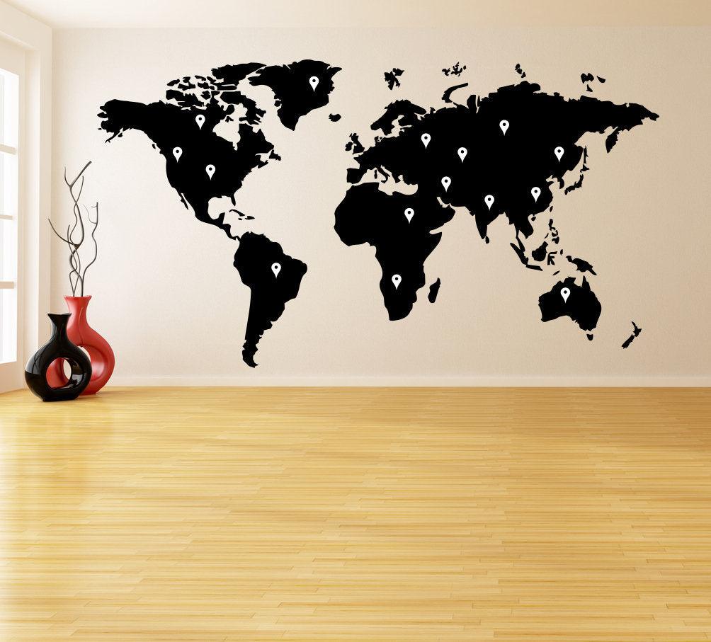 Large world map wall decal in black, elegantly displayed on a wooden floor, perfect for home decor.