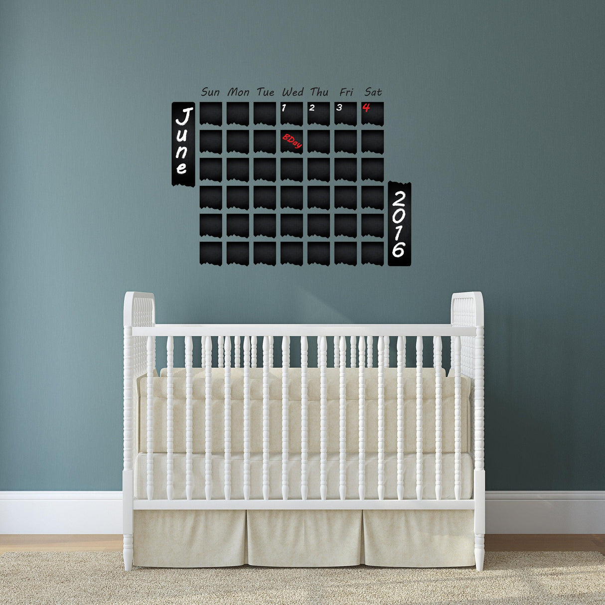 Chalkboard wall planner featuring a monthly calendar layout for June 2016 above a white crib in a cozy room.