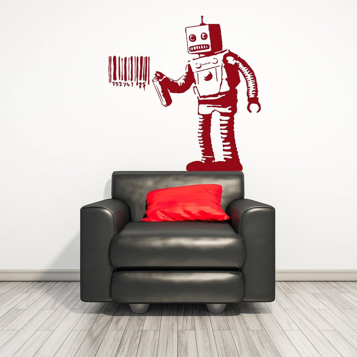 Banksy Barcode Robot Wall Sticker on a white wall above a black armchair with a red cushion, showcasing urban street art.