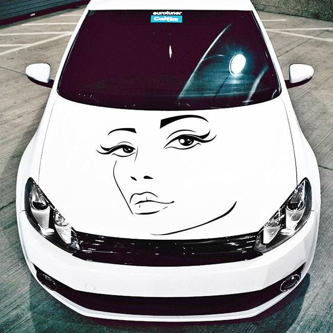 Stylish white car hood featuring a striking female face decal with elegant eyelashes and a chic design.