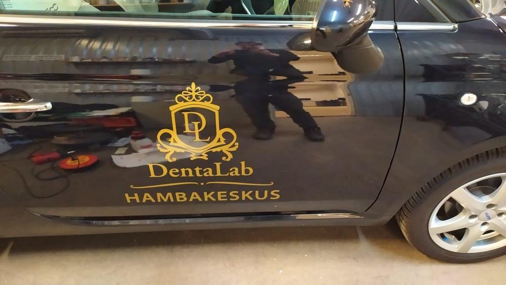 Custom vinyl decal on a black car door featuring 'DentalLab Hambakeskus' logo.