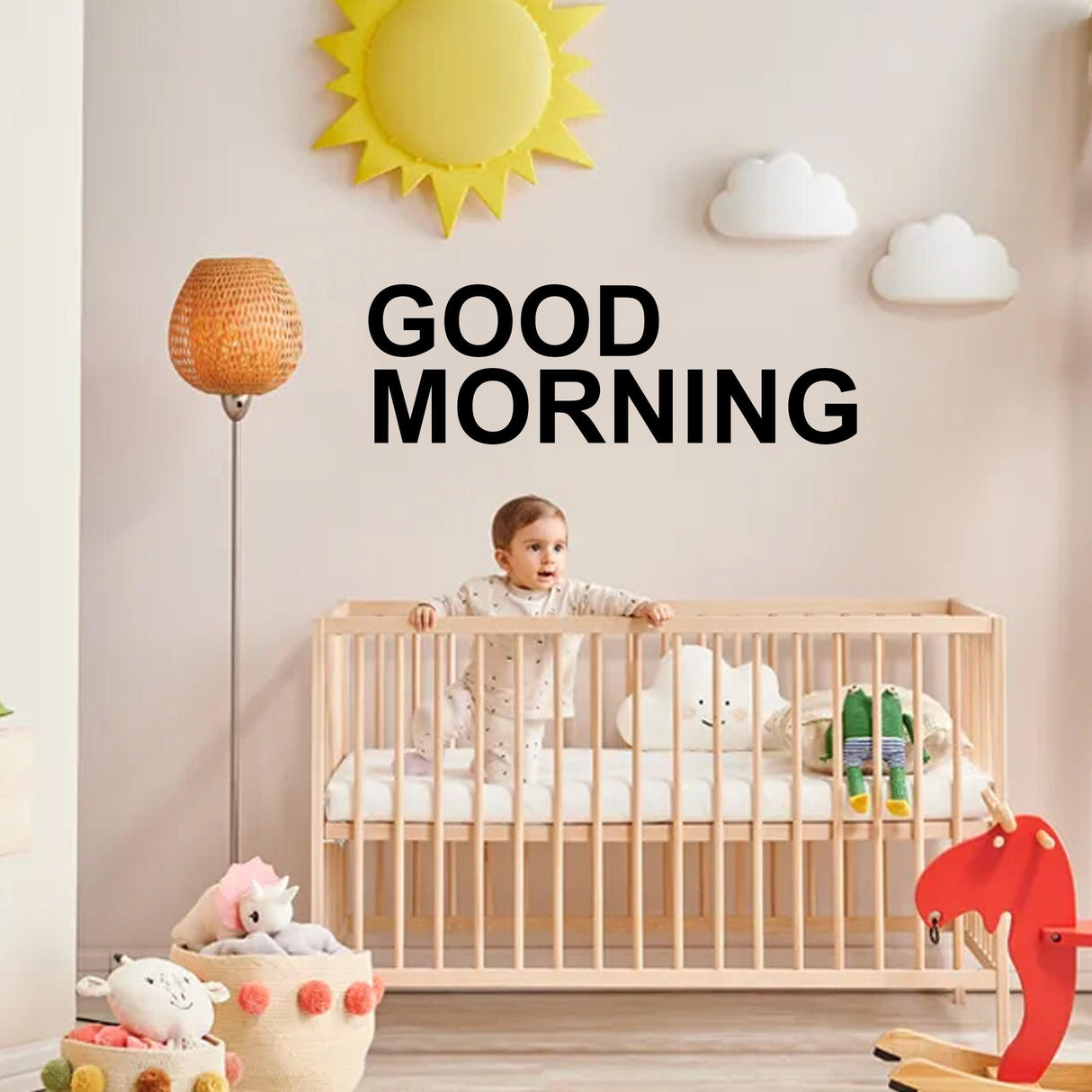 Baby in crib with "Good Morning" wall decal, bright nursery with playful decor and warm lighting.