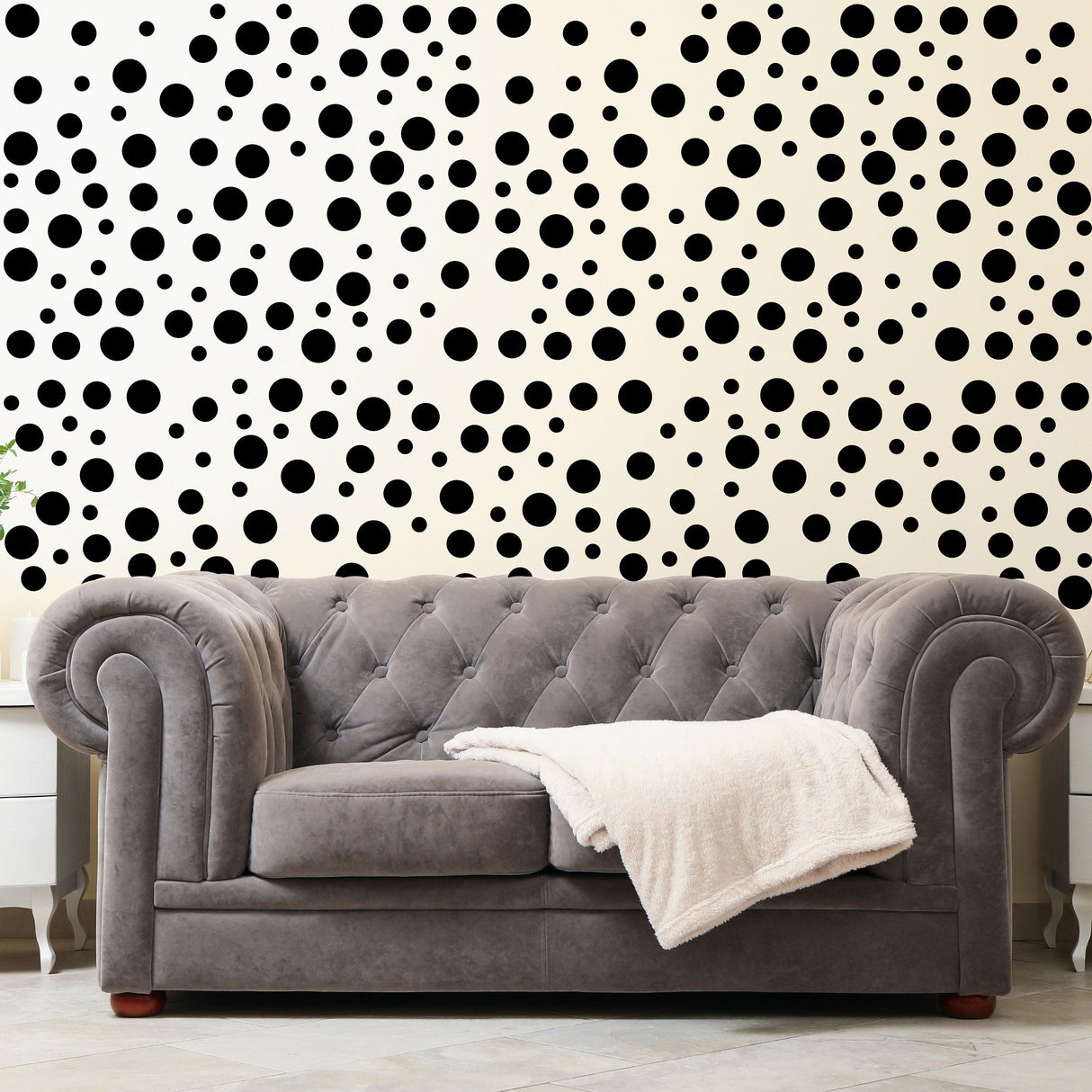 Polka dots wall decals in black on beige wall behind a gray tufted sofa, adding playful decor to a stylish room.