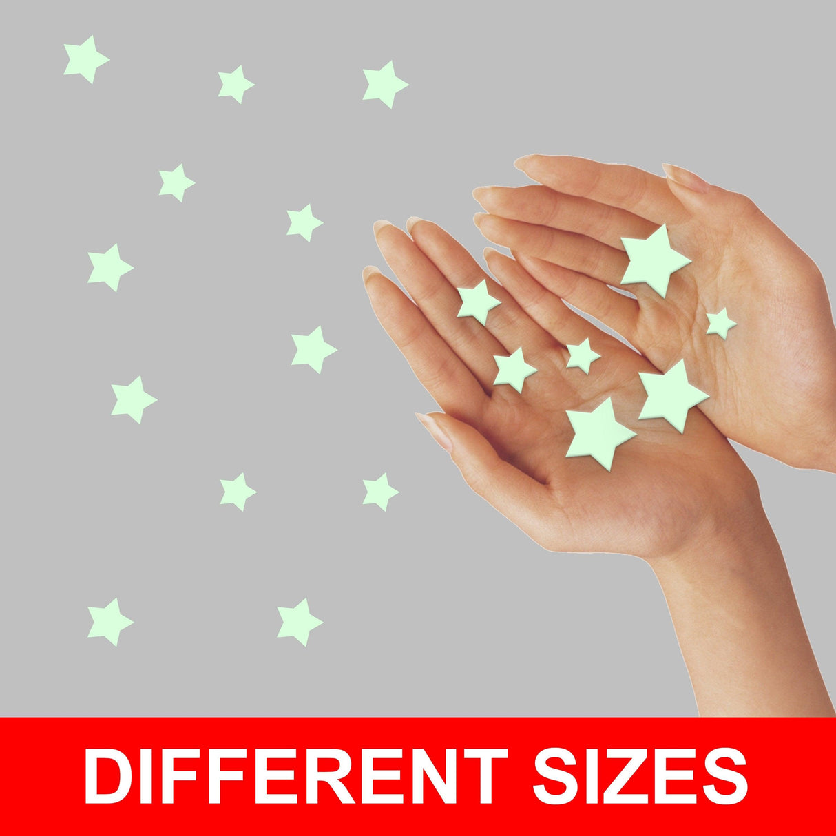 Hands holding glow in the dark stars stickers of different sizes for kids' room décor.