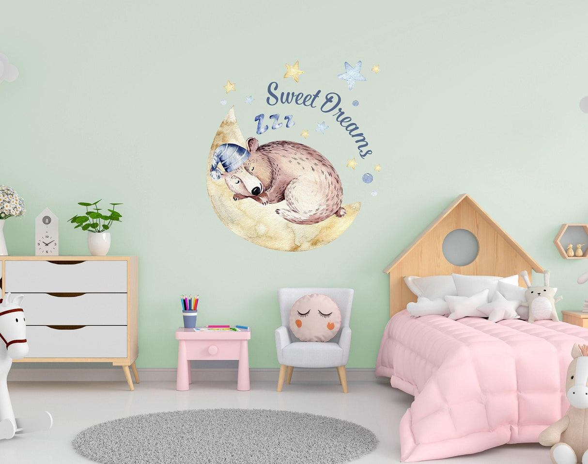 Cute sleeping animal wall sticker in a nursery, featuring a moon and 'Sweet Dreams' text for baby room decor.