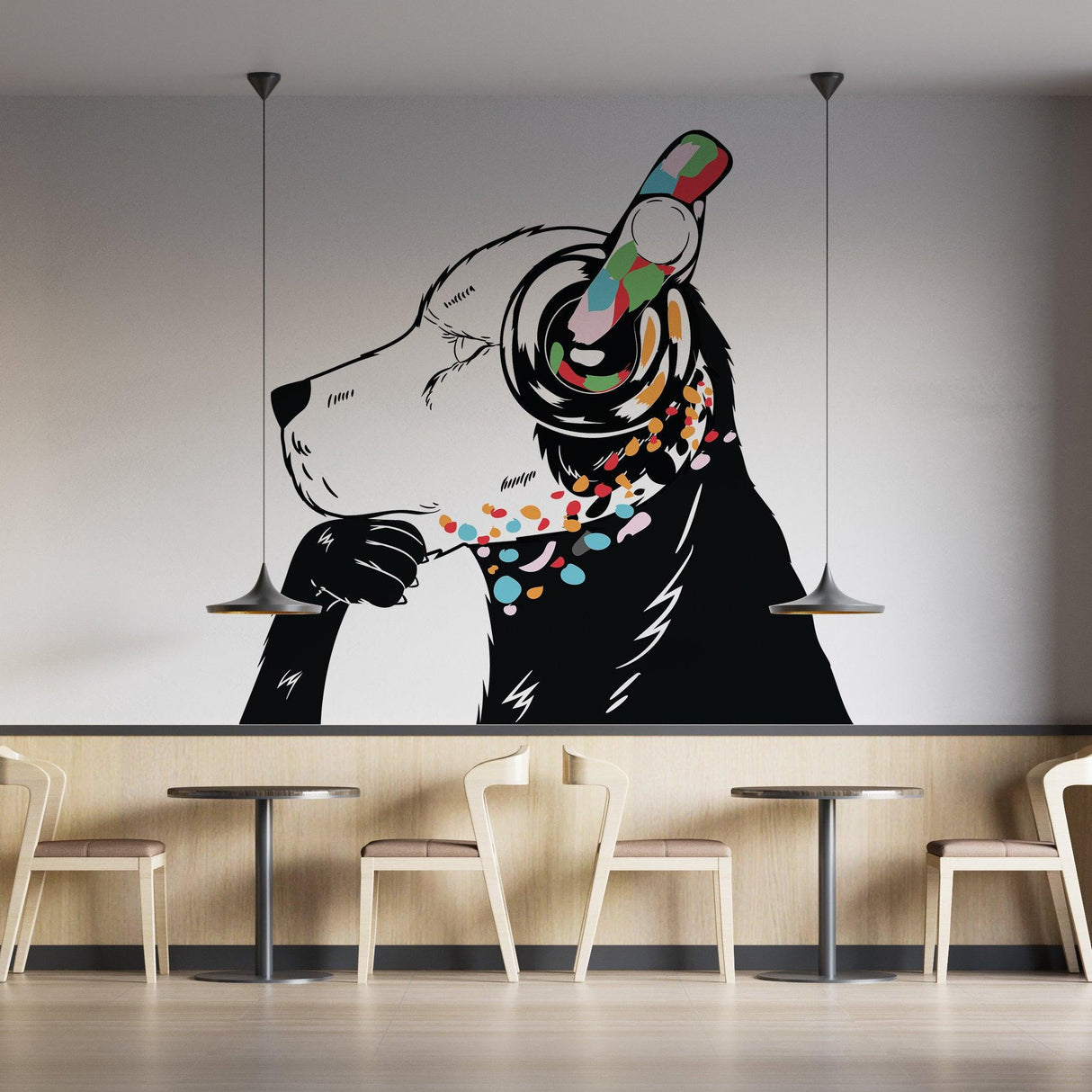 Stylish dog wearing colorful headphones on a graffiti-style wall in a modern cafe setting.