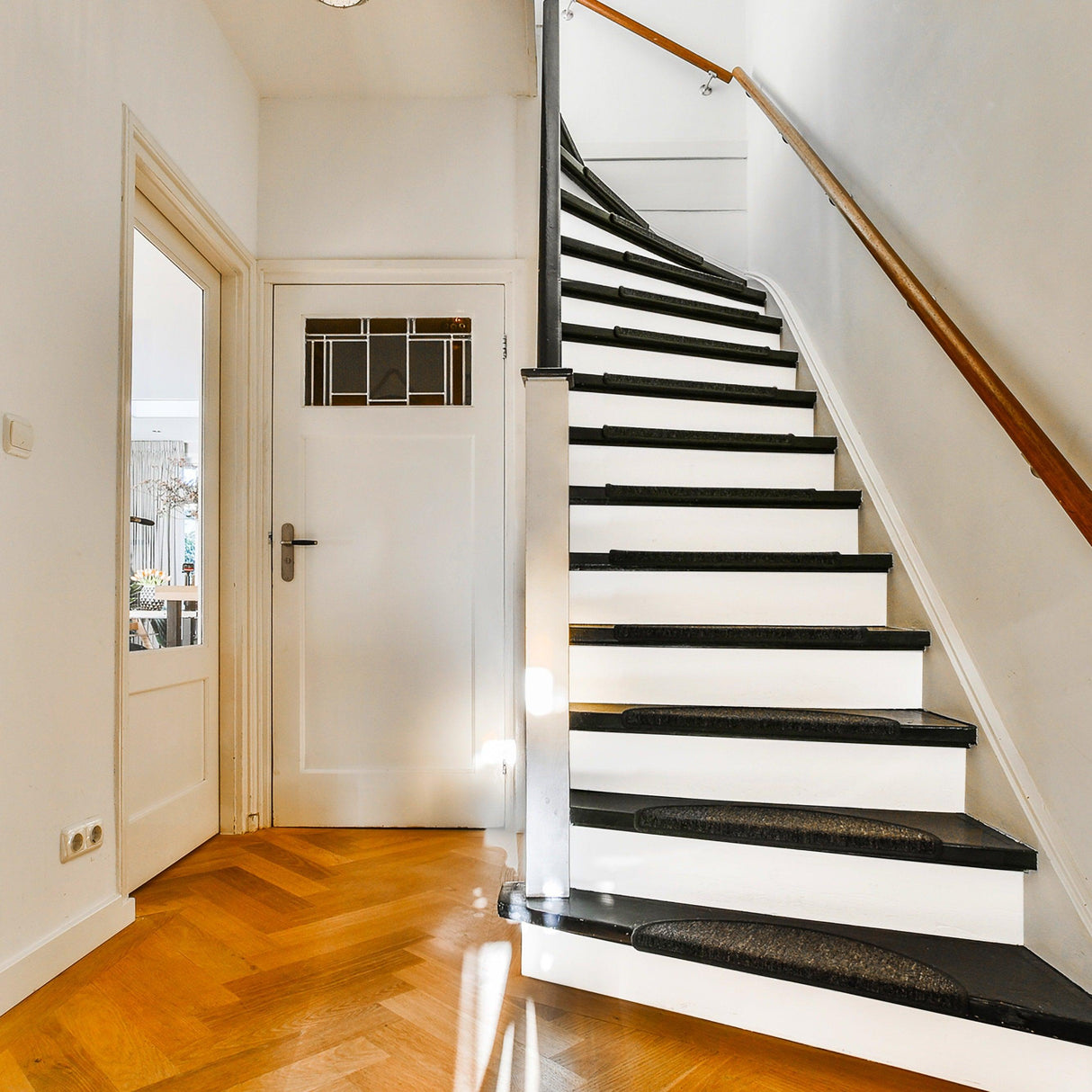 Elegant staircase with white risers and black treads, showcasing stylish home decor.