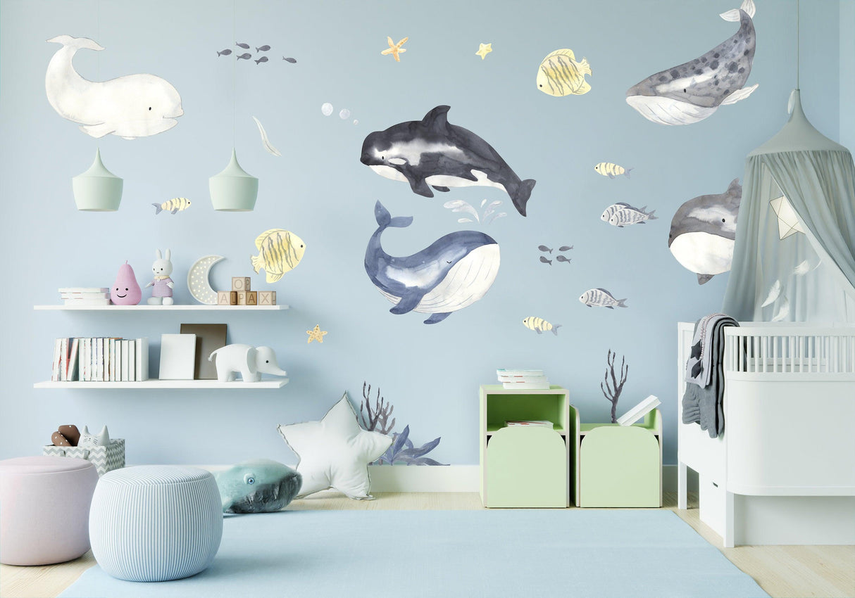 Colorful ocean whales wall sticker in a baby boy nursery, creating an enchanting underwater scene for kids.