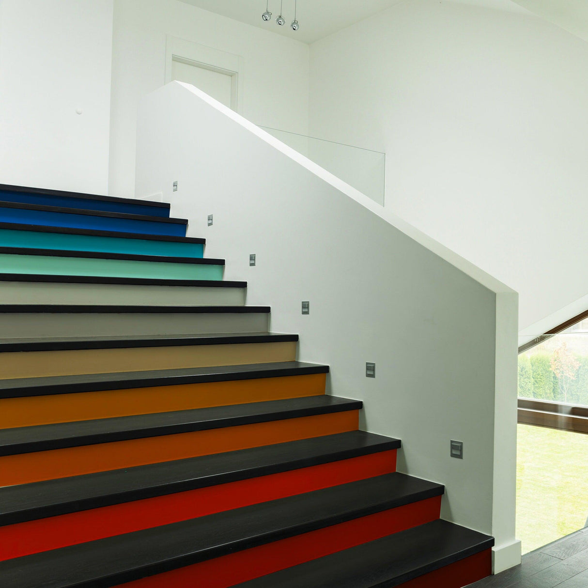 Stunning staircase with gradient color self-adhesive risers stickers, enhancing modern home decor with vibrant hues.