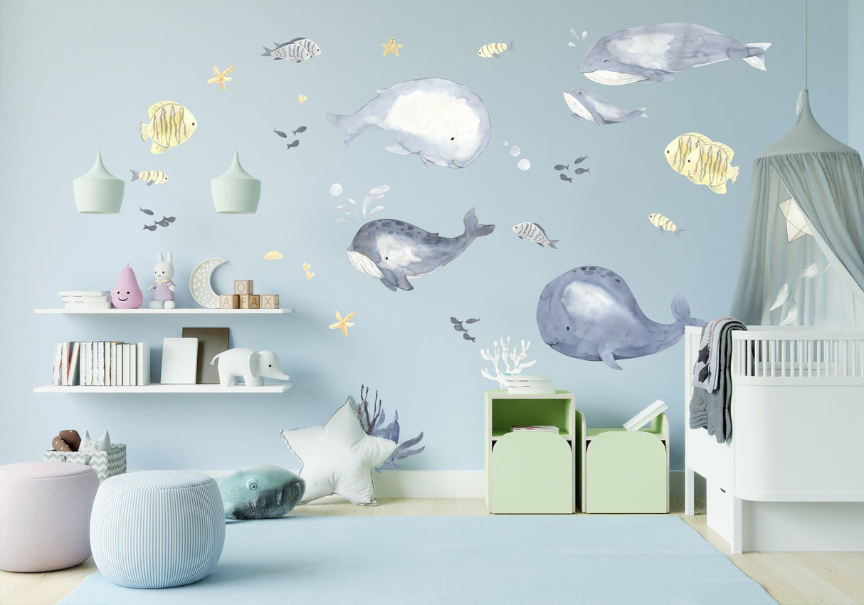 Whimsical sea whales wall sticker in a baby boy nursery, featuring colorful fish and playful decor.