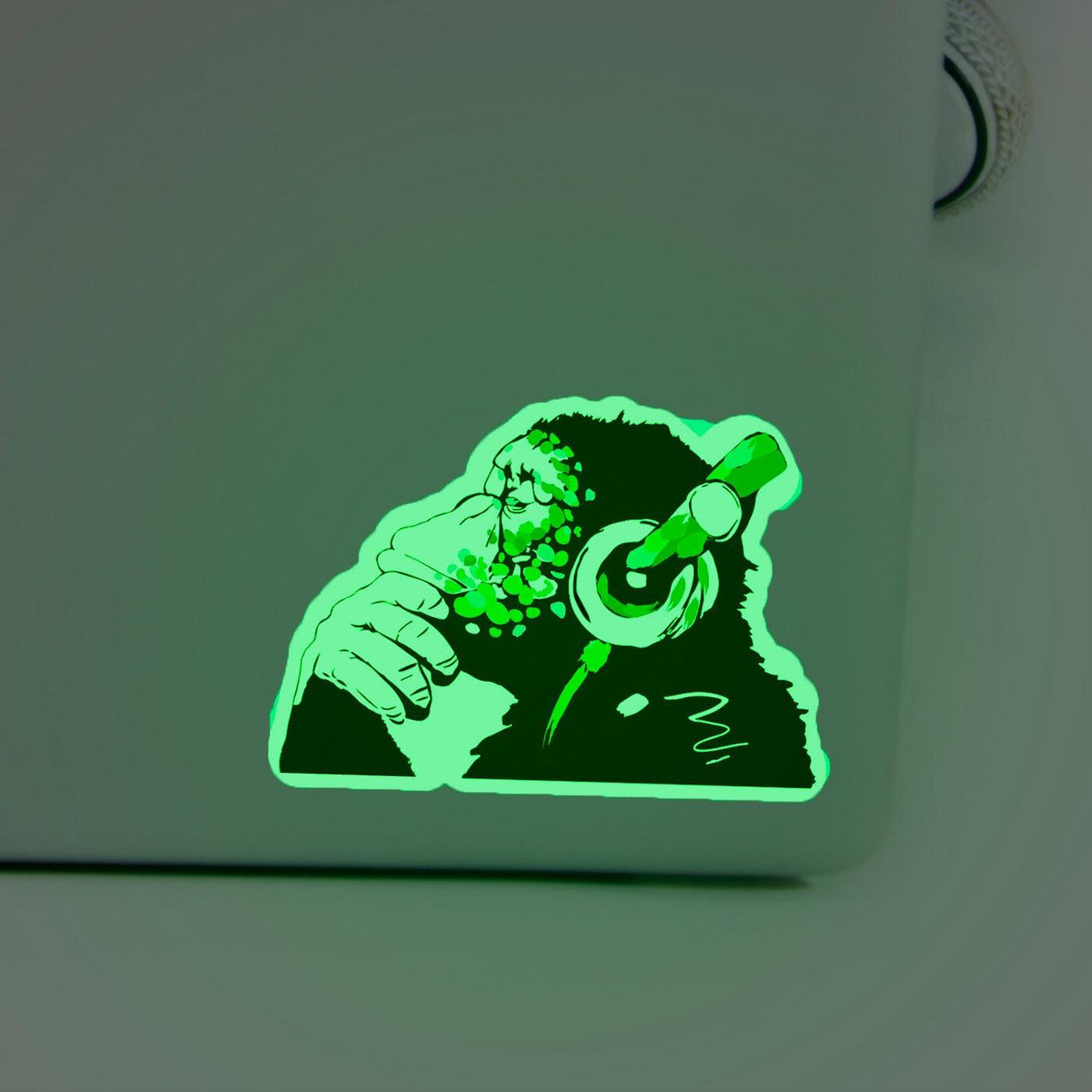 Glow in the dark monkey vinyl sticker with headphones on a laptop, ideal for music lovers and Macbook users.