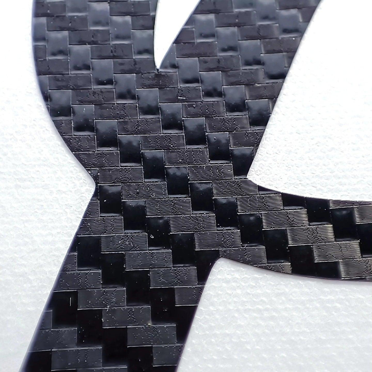Close-up of a personalised vinyl name decal made from durable carbon fibre material.
